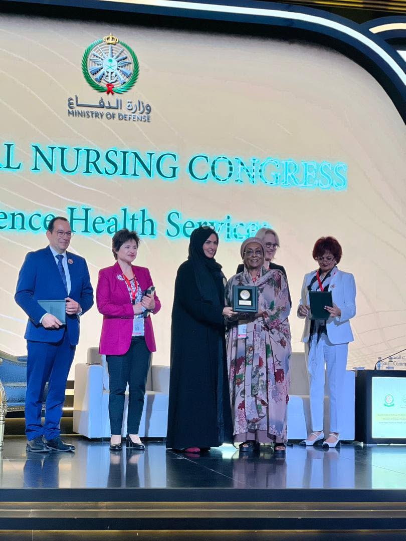 Edna Adan Ismail receiving an award on stage at an international nursing congress